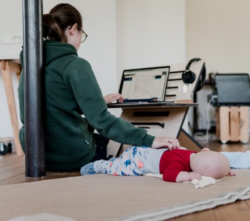 Woman working from home and taking care of her infant.