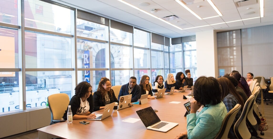 Diverse group of employees sitting at a conference table.