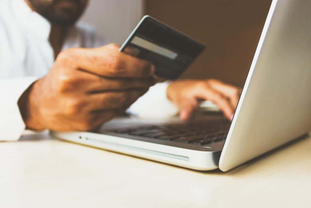 Person entering credit card information into a laptop.