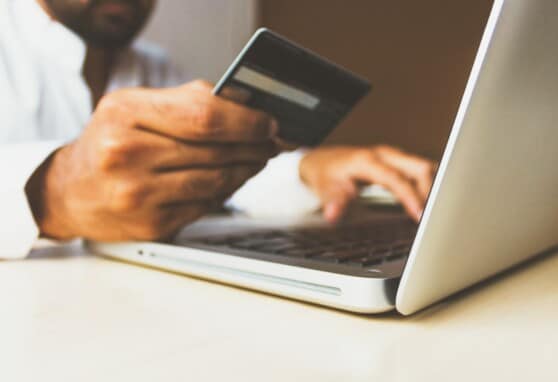 Person entering credit card information into a laptop.