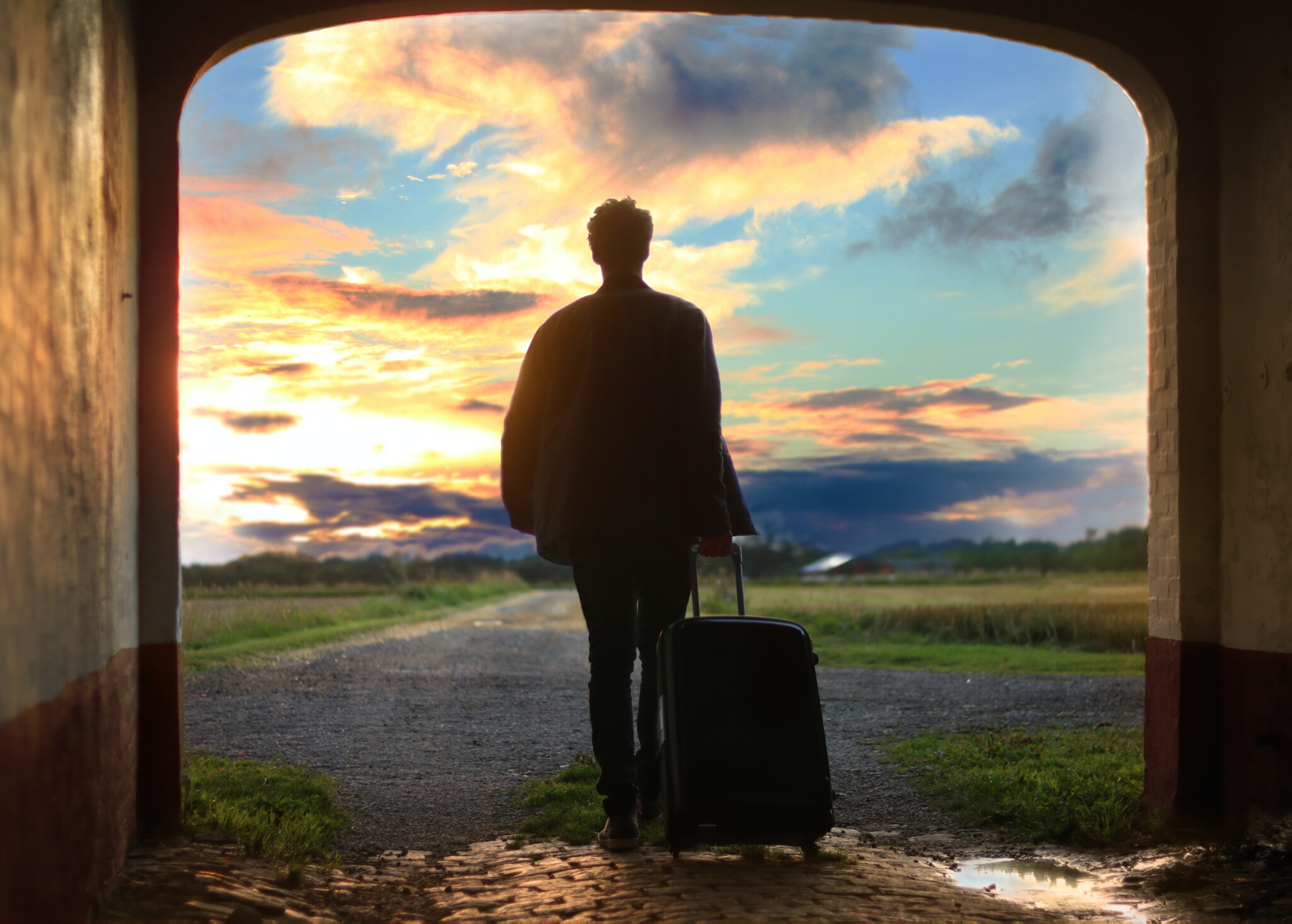 Man standing in a doorway against a sunset.