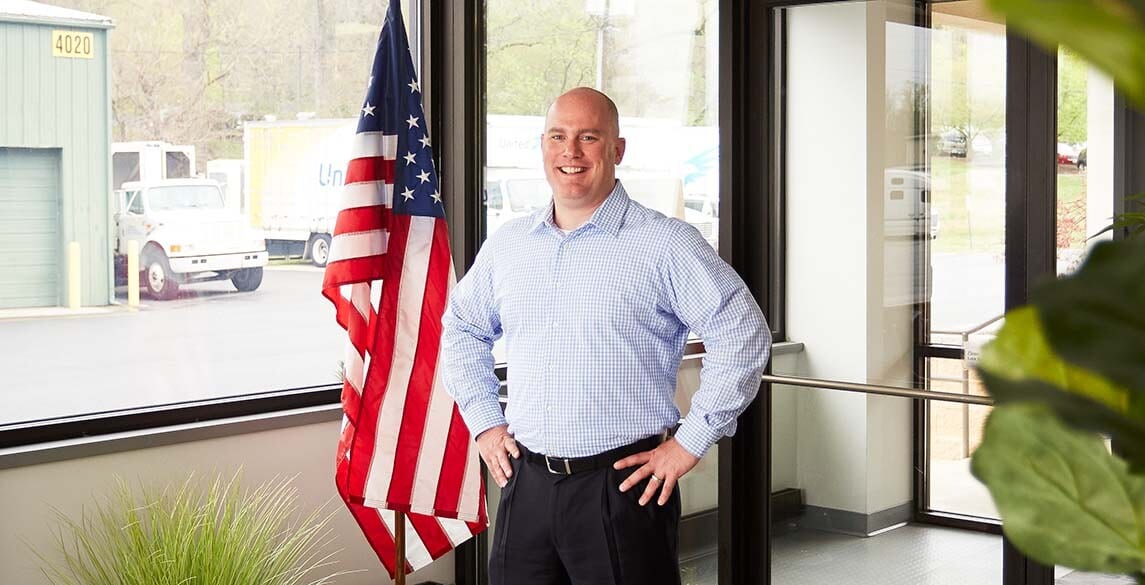 Jimmy Murray standing in front of American flag
