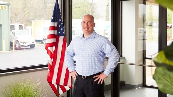 Jimmy Murray standing in front of American flag