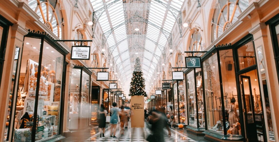 Mall decorated for Christmas with people shopping.