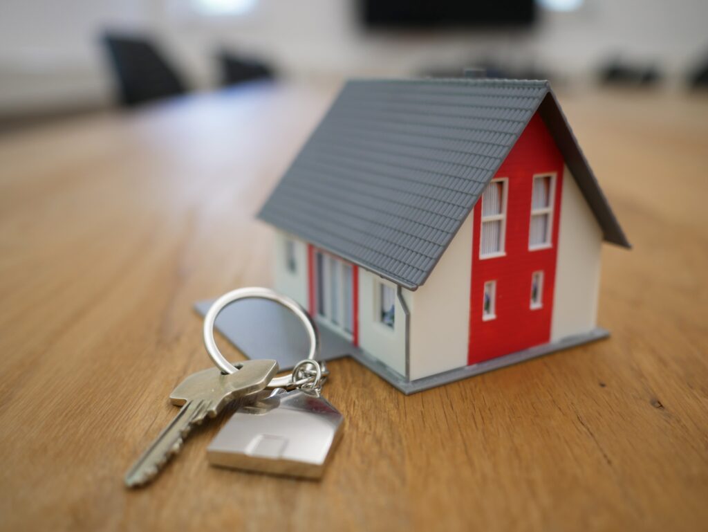 Miniature house next to keychain on a table