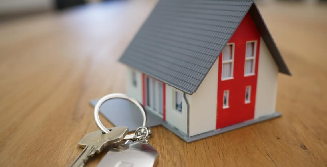 Miniature house next to keychain on a table