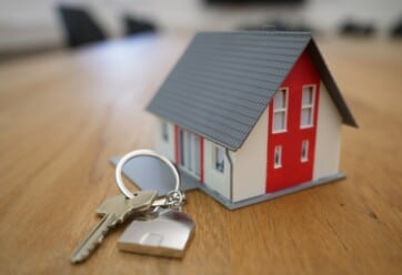 Miniature house next to keychain on a table
