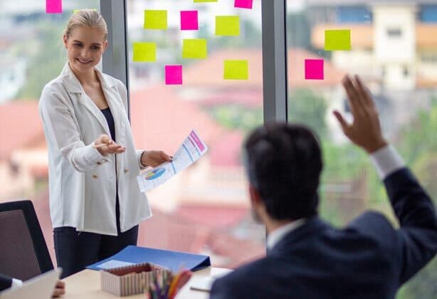 team talking in conference room with sticky notes on wall