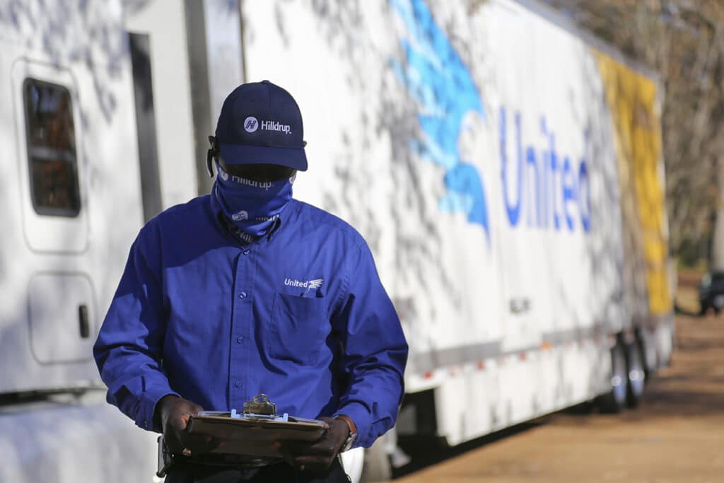 Picture of a van operator wearing a mask outside of their truck.