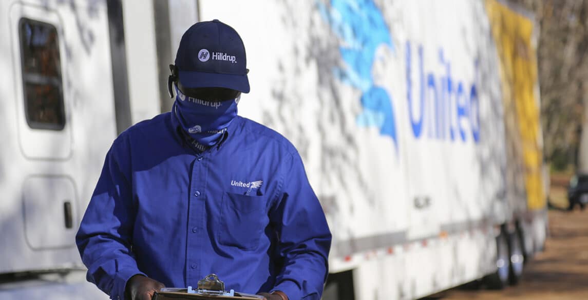 Picture of a van operator wearing a mask outside of their truck.