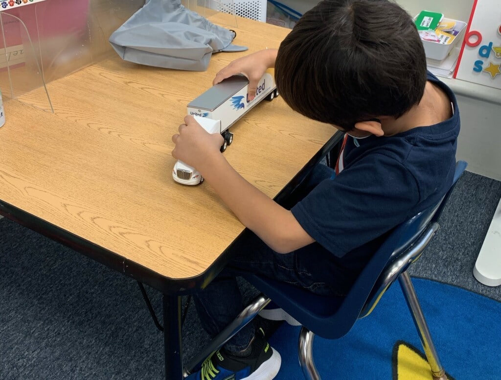 A student gets a closer look at a toy truck modeled after Hilldrup's fleet.