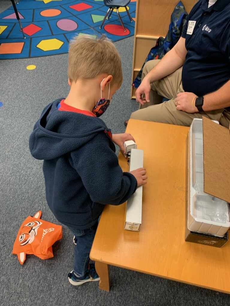 A young student studies a toy truck. 