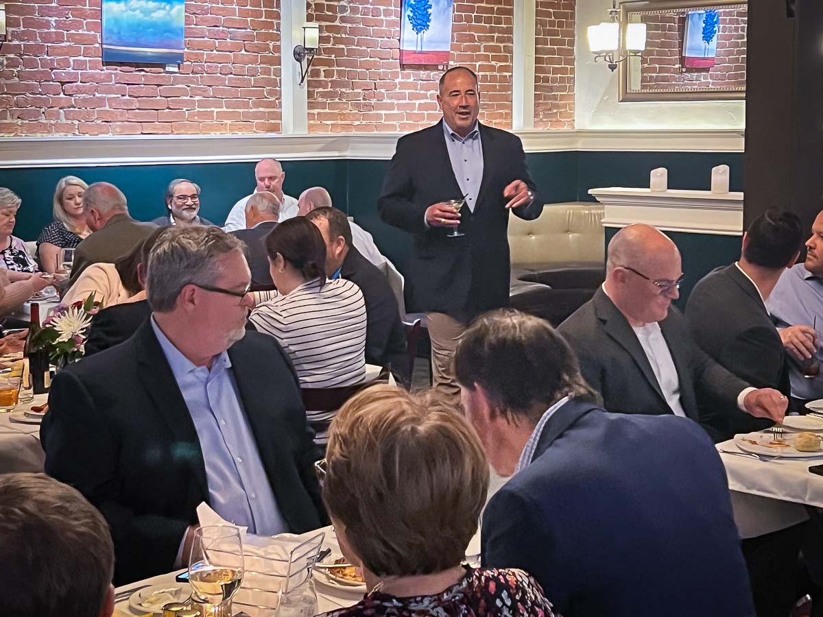 Man speaking to a group at dinner