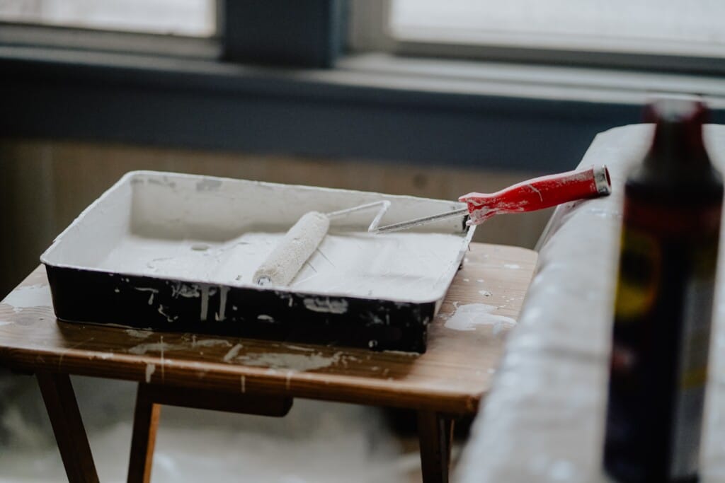 Picture of a paint roller with white paint.