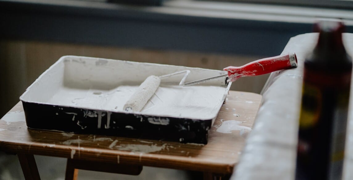 Picture of a paint roller with white paint.