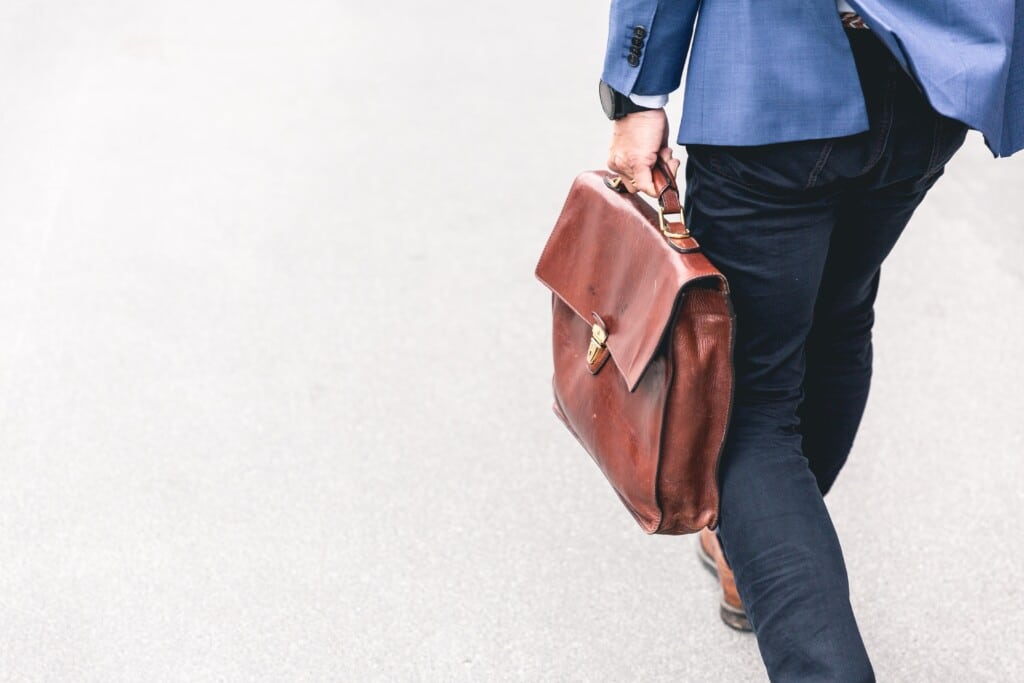 Man in a blue suit carrying a leather briefcase
