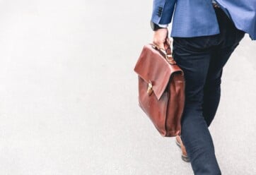 Man in a blue suit carrying a leather briefcase