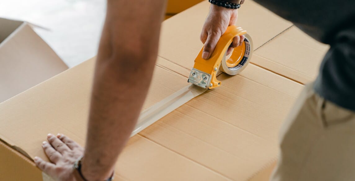 Man tapes up moving box