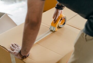 Man tapes up moving box