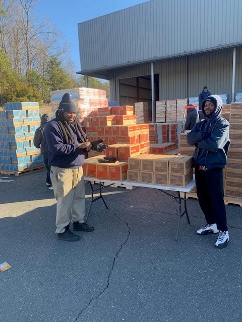 Charlotte service team members with cases of Girl Scout cookies 