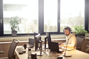 Man at desk with several computer monitors