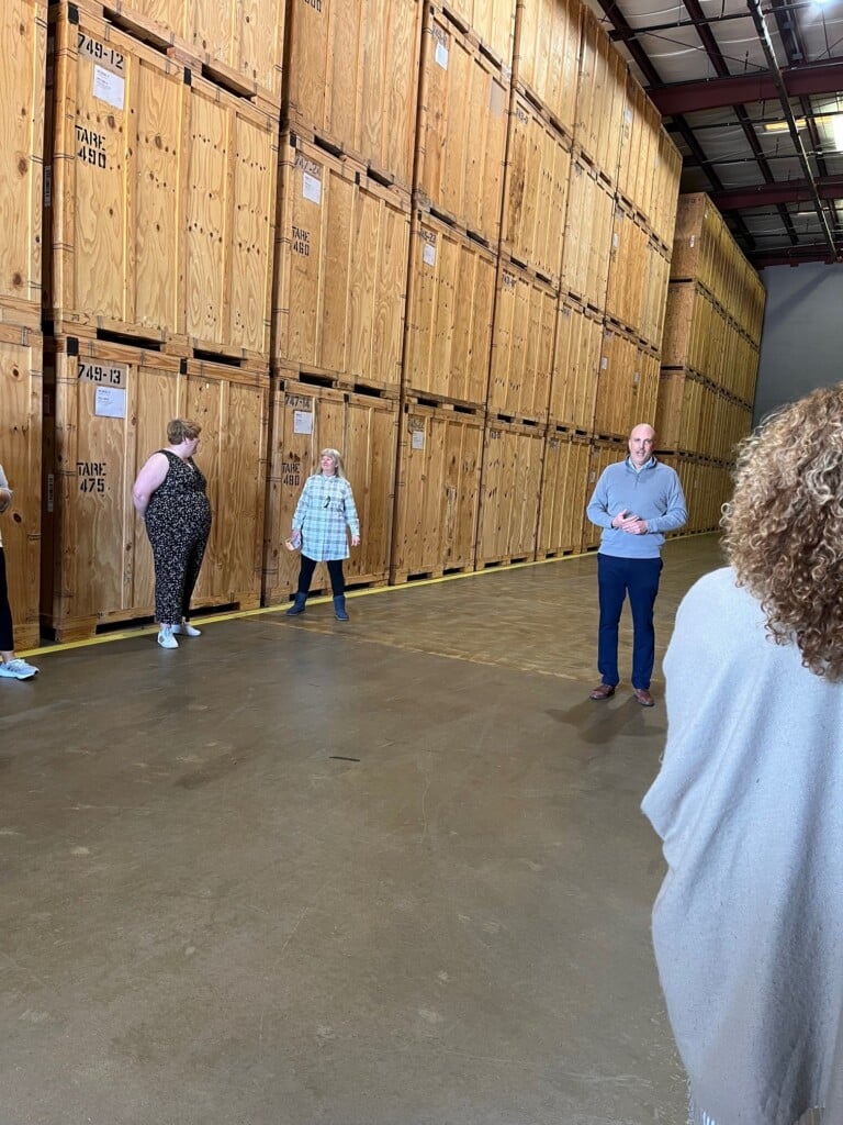 John Seal gives tour in warehouse. 