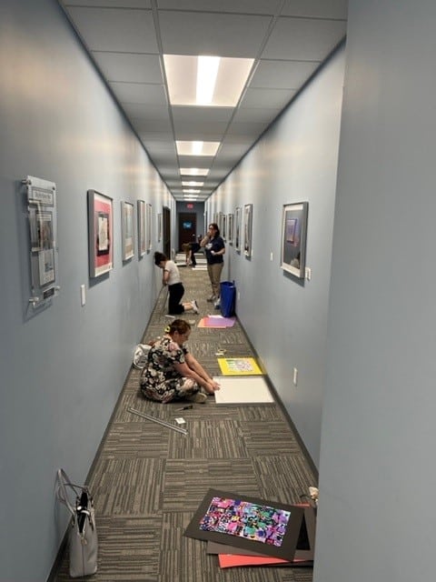 Art teachers from Stafford County Public Schools install new artwork in hallway. 