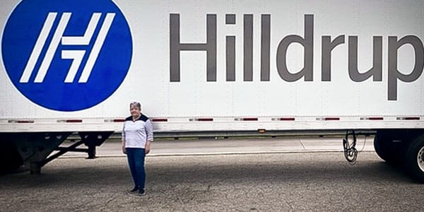 Brenda Harless standing by Hilldrup truck