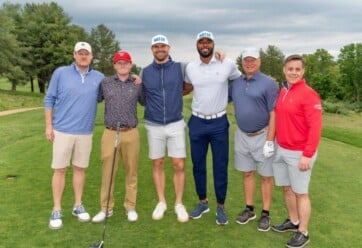 Team Hilldrup with Chris Long and E.J. Manuel on a golf course.