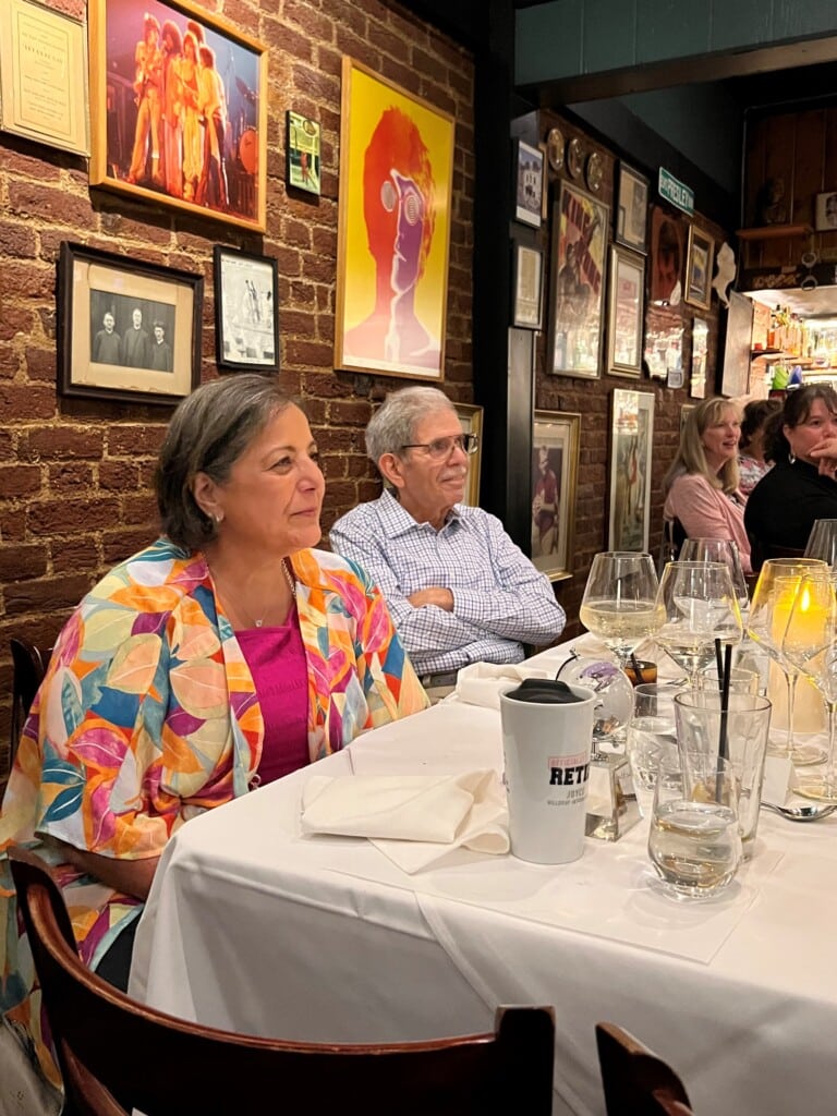 Joyce Lopez listens amongst friends and family to a speech in her honor. 