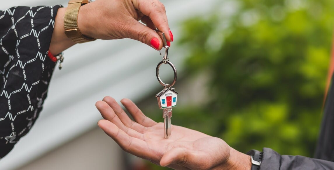 realtor passing the keys of a home to a new homeowner