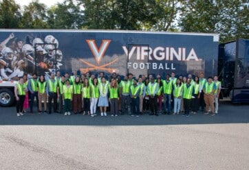 UVA Darden School of Business students pictured in front of UVA football branded truck.