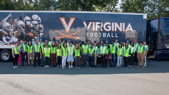 UVA Darden School of Business students pictured in front of UVA football branded truck.