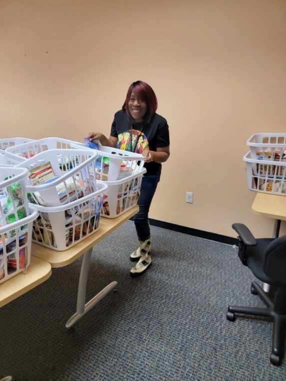 A volunteer organizes food donations into baskets. 