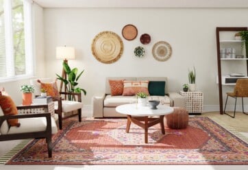 Modern style living room with a red rug, circle coffee table and several seating options.