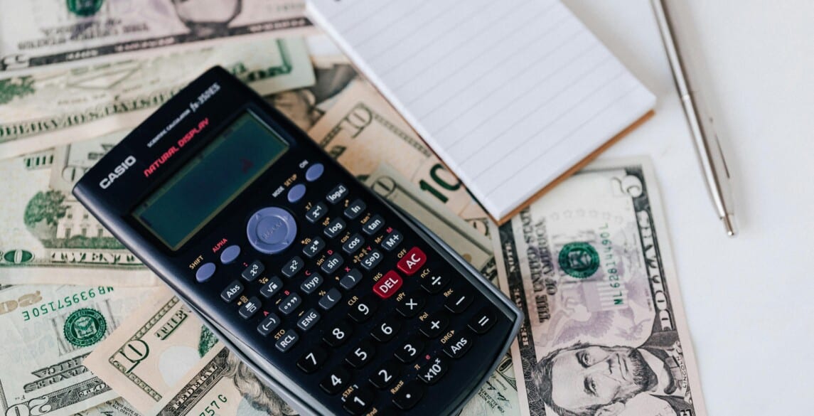 calculator and notepad with cash