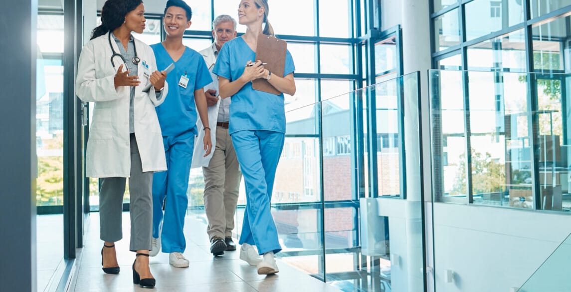 Healthcare, doctors and nurses walking together for discussion, planning or schedule. Diversity, men or women medical group talking about support strategy, medicine and surgery teamwork in hospital.
