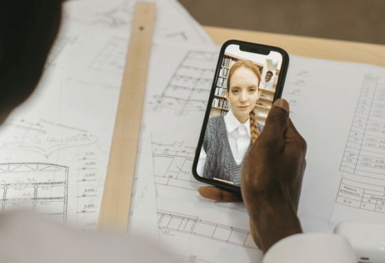 women on video call with architectural drawings in background