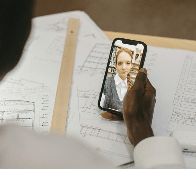 women on video call with architectural drawings in background