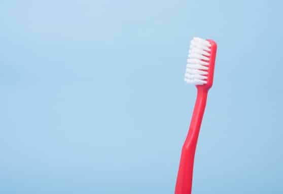 red toothbrush against blue background