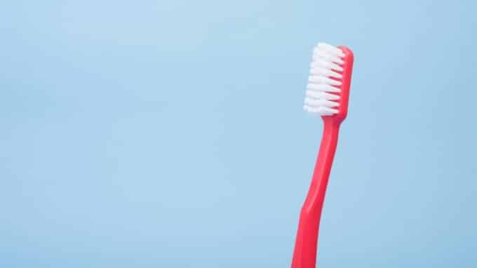 red toothbrush against blue background