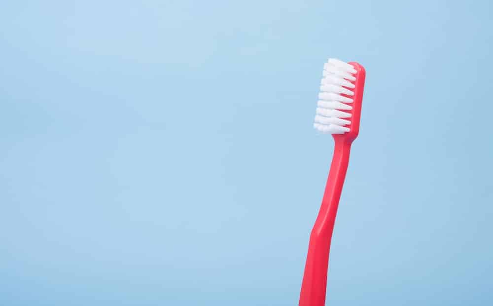 red toothbrush against blue background