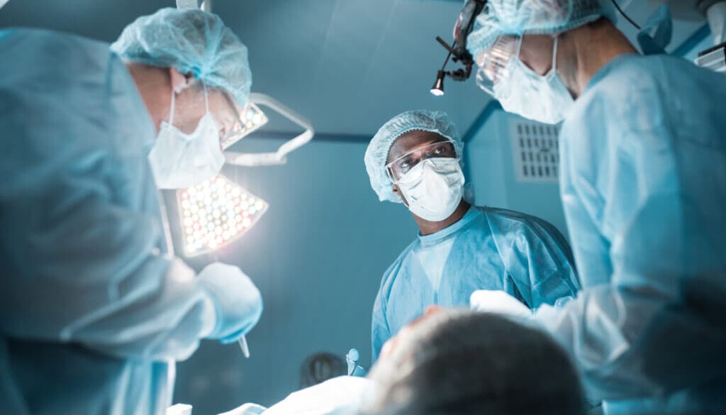 bottom view of multicultural surgeons operating patient in operating room