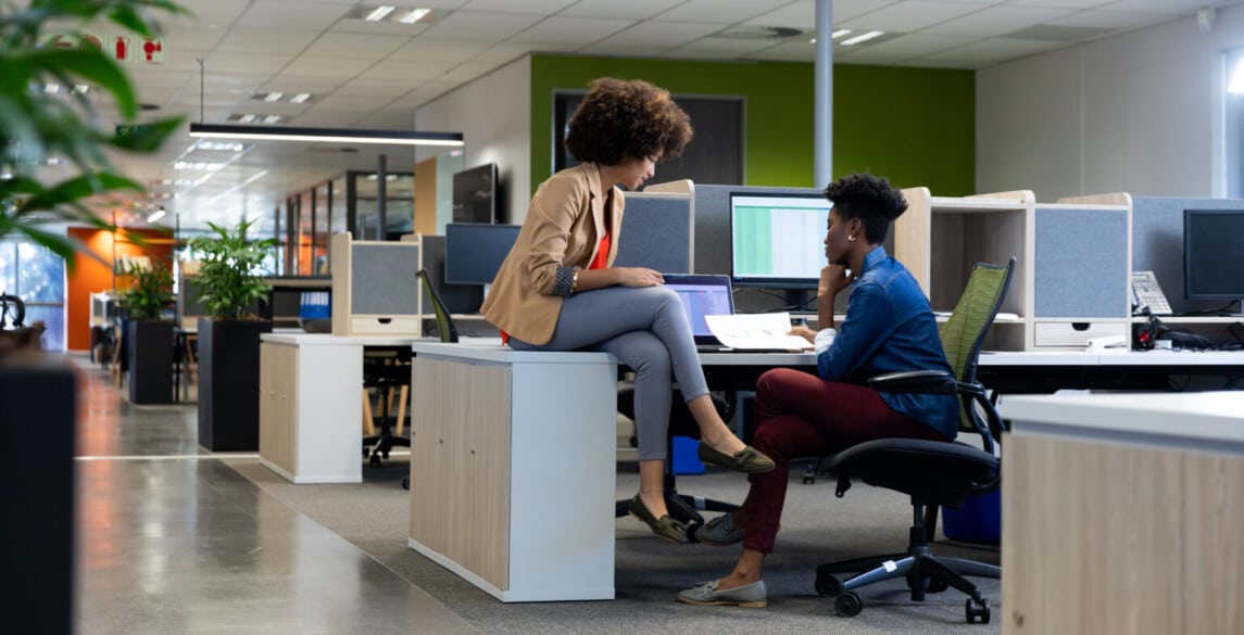 young multiracial female colleagues discussing in office setting