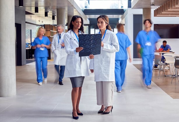 Two female doctors in white coats talking.