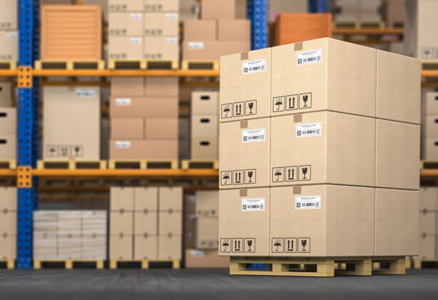 Cardboard boxes on a pallet in a neatly organized warehouse.