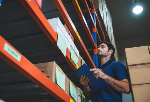 Warehouseman checking inventory on warehouse racking.