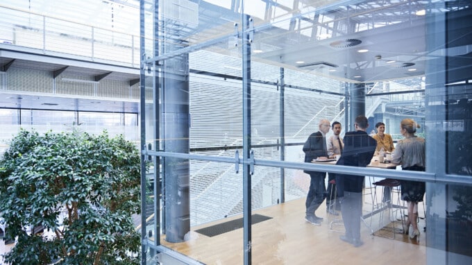 professionals sitting at a table in a glass-walled conference room