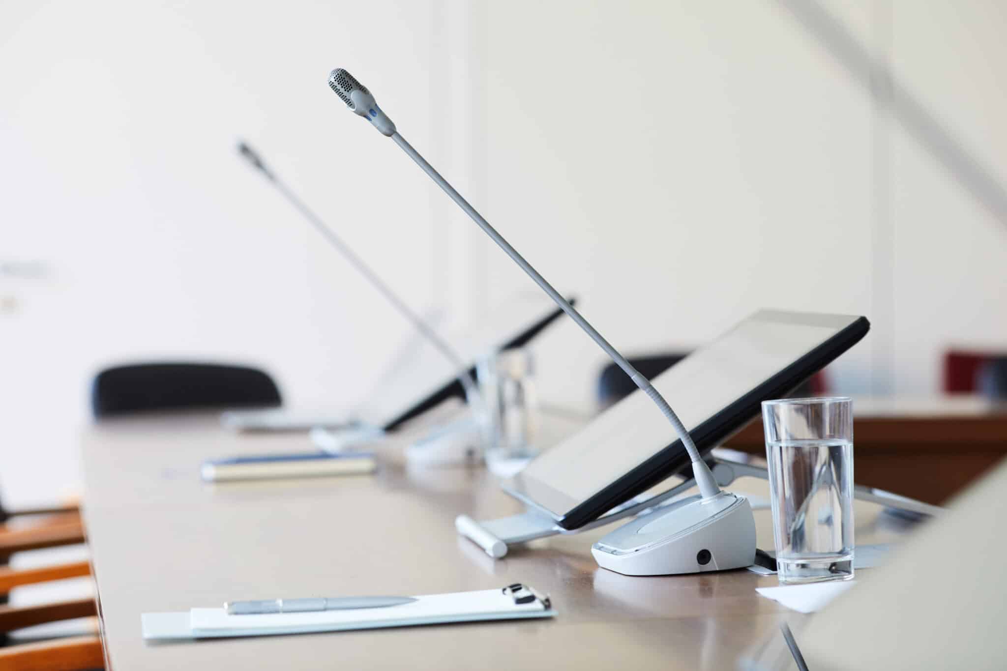Close up of conference room equipment, including individual tablets and microphones.