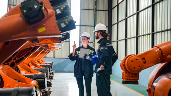 two technical workers reviewing a piece of specialized machinery